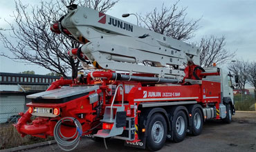 A massive boom pump truck is enroute to its destination