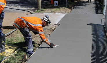 A mason is leveling the screed on site delivered by West London Concrete